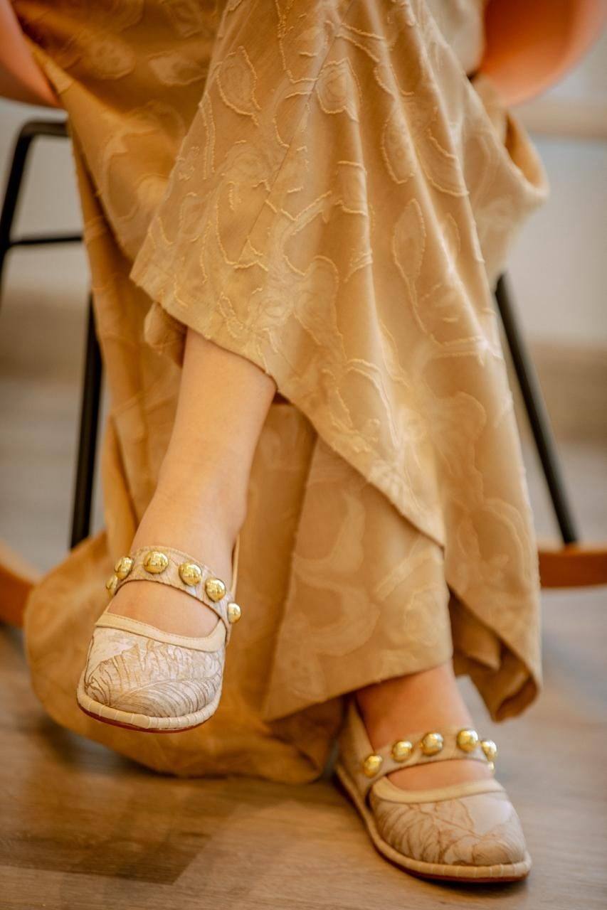 Baletas de encaje con perlas doradas, con los pies cruzados